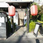 テーブルの上に並べた焼とりをアテに飲むも良し、コース料理を注文して食べるも良し。気軽に訪れ、食事とお酒を楽しむことができます。店先に吊り下げられた赤い提灯が目印。