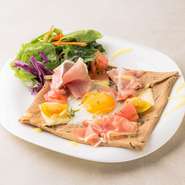 フランスの定番料理『ガレット』を、北海道産のそば粉で仕上げた一品。独自の配合で、風味豊かに焼き上げたそば粉生地が絶妙です。パリパリ生地にとろ～り半熟卵と生ハムの塩気がベストマッチ。
