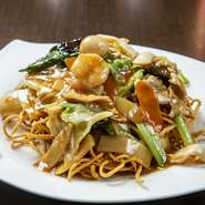 エビ、キクラゲ、青梗菜など4種類以上の具材が入っていた人気の焼きそば。麺は太麺を使用。麺の揚げた香りとパリパリの食感がたまりません。添えられた辛子をお好みでどうぞ。