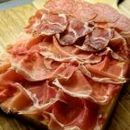 イタリア・モントルシ社こだわりの生ハムを木の器一面に盛り付けた生える一品。ほぼすべてのワインに合うおつまみです。