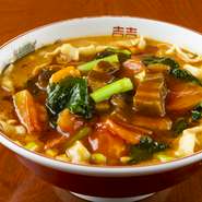 添加物であるかんすいを使わず、小麦から手作りした刀削麺。高い技術が求められる本格派の中華麺です。牛肉がごろごろ入った贅沢麺は、ごまペーストのスープにトマトの酸味と野菜のコクがアクセントです。