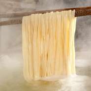 武蔵野うどんの一番の特徴であるコシのある太麺。何も漬けずそのままひと口噛みしめると、多加水麺ならではのモチっとした食感とほのかな塩気、小麦の風味が口のなかに広がります。