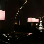 ライティングの角度や、煙の立ち上り方まで計算された見事な空間。内装の設計・デザインには一級建築士が携わり、国内外で活躍するメイクアップアーティストのアート作品がディスプレイされています。