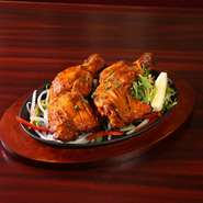 骨付きチキンをヨーグルトやスパイスに漬け込んでタンドール窯で焼き上げた料理