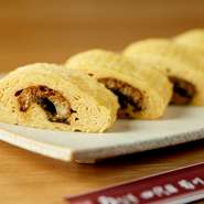 秘伝のタレで焼きあげたうなぎの蒲焼きを巻いた、トロトロのだし巻き卵。熱伝導の高い銅板の卵焼き器で卵を薄く焼き、何層にも重ねて巻きあげてあります。噛む度に口の中でほどけ、蒲焼きとほどよく混ざり合います。
