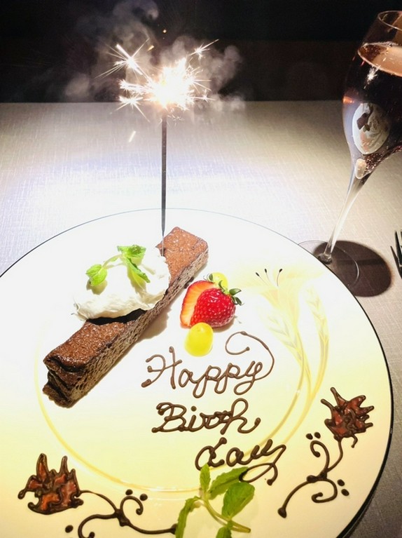 パティシエが描くメッセージプレートとスパークリングワインを