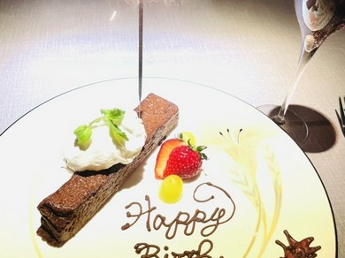 パティシエが描くメッセージプレートとスパークリングワインを