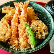 通常の『天丼』は、海老天が1本ですが、こちらの『上天丼』には2本ついています。薄衣に包み、こめ油100％でカラッと揚げられており、胃もたれしにくいと好評です。