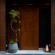 木格子の入口の奥には、桜の一枚板のカウンター席、ドラマチックな墨色の壁、和の雅が漂う天井に囲まれた空間が広がり、天満の街の喧騒からワープしたような落ち着き感。知っておくと、多彩なシーンで重宝します。