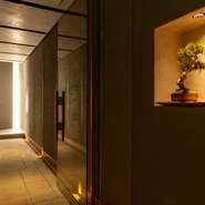 一級建築士が手掛けた高級感あふれる店内が自慢。オシャレに配置された盆栽や間接照明が落ち着いた雰囲気をつくっています。ヒバの1枚板を使ったカウンターやヨーロッパのビンテージ椅子などが上質な空間を演出。