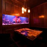 水槽横にあるテーブル席は、4名～5名ほどのグループで過ごせます。悠々と泳ぐ魚の姿を間近で見られるラグジュアリーさも好評。気心知れた友人や同僚と、会話の華を咲かせてみてはいかがでしょう。