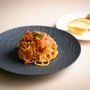 登別にある【望月製麺所】から取り寄せる道産小麦100％の生パスタを使用。自家製の生ハムを入れたオリジナルのトマトソースで仕上げた一皿です。自家製ブリオッシュパンと合わせてオーダーするのがオススメ。