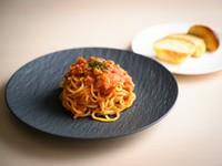 登別にある【望月製麺所】から取り寄せる道産小麦100%の生パスタを使用。自家製の生ハムを入れたオリジナルのトマトソースで仕上げた一皿です。自家製ブリオッシュパンと合わせてオーダーするのがオススメ。