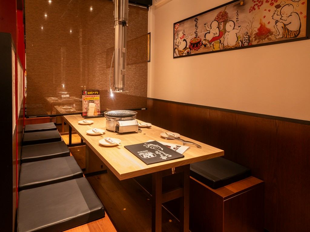 半個室のテーブル席をご用意、壁には子鬼のアートがお出迎え。