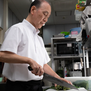 厨房で食材に火を入れて、すぐに食べられる状態にする珍しい提供スタイル。職人が鍋についてタイミングを見計らっています。できたての鍋をできるだけ早く届けたいという心意気があるからこそ。