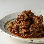 牛肉を数種類のハーブ・スパイスとココナッツミルクの水分のみで長時間煮込む、風味豊かな一品。限界まで水分を飛ばしながら煮込んでいるので、旨みが凝縮し多層な味わいを引き出している。