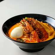 シンガポール伝統料理で当店の看板メニュー。スパイス・唐辛子・ココナッツを融合したスープが決め手です。他のお店と違い、魚介・スパイス・ココナッツのバランスが特徴的で麺は現地同様に２種類を使用しています。