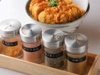 “味変”も、ボリュームたっぷりのかつ丼の楽しさの一つ。粗挽きにんにく、ピンク岩塩、粗挽き黒胡椒、山椒を使って味の変化を楽しむこともできます。