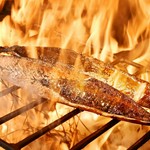 当店の藁焼きタタキは全て注文後に藁で焼き始める焼き切りに拘っております。
藁焼きで鰹の皮目を炙り、中にまで熱が伝わらないうちに、熱いまま切り分けします。香ばしい香りと藁のほのかな香りをお楽しみ下さい。