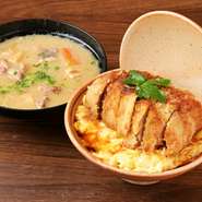 名物のカツ丼は、話題の「卵でとじないカツ丼」。250グラムの分厚いカツは低温調理してから揚げることで、外はサクッと中はしっとり仕上げています。ふわトロ卵と高菜ご飯がベストマッチ。箸が止まらない逸品です。