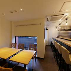 清潔感のある白一色の部屋。木目を基調とした席で食事を楽しむ