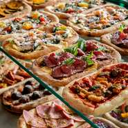 ピザ窯で焼き上げる芳ばしいピッツアが堪能できるイタリア料理店です。ランチは日替わり5種のピッツァが食べ放題！サラダ、スープ、パスタ、肉料理、魚料理から、一品メインを決めて注文するスタイルです。