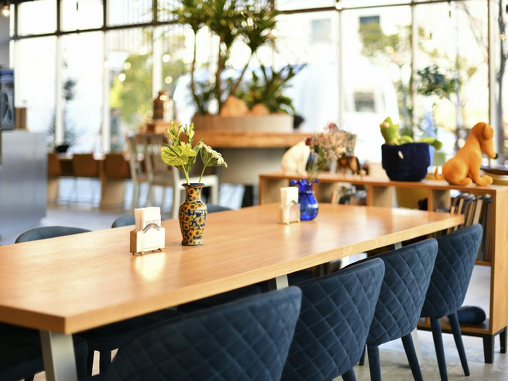 ガラス張りの大空間に人・食・モノがつながる“大喫茶店”を創出