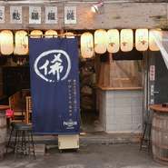 近鉄日本橋駅から徒歩5分。二ツ井戸町通と高津入堀筋の角にあるのが【うどんの極心まれ】です。店主のこだわりはズバリ“無添加・無加調”。保存料や添加物を使わず、素材本来のおいしさを引き出しています。