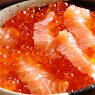 北海道産の新鮮な鮭のお刺身といくらを日高産の昆布醤油に漬け込み熱々の銀シャリにたっぷりと乗せた贅沢な海鮮丼です。