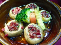 生ハム（ハモンセラーノ）を刻んで詰めたマッシュルームのアヒージョ風です。生ハムの塩気とマッシュルームが、ワインとてもあいます。