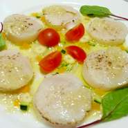 お刺身用のホタテ貝柱を旨味を引き出すために火で炙り、白ワインビネガーと玉ねぎベースの自家製ソースをかけております。