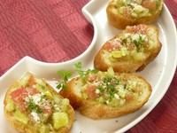 こんがり焼いたガーリックトーストに、アボカドとトマトなどをのせたブルスケッタ。イタリア料理の軽食の一つ。おつまみや前菜とししてどうぞ。