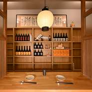 店舗の奥に設置されたカウンター席は間仕切りで区切られ、周囲を気にせず利用可能。対面に並ぶ酒ボトルの装飾が、空間に華やかさを添え、洗練された印象を醸し出しています。