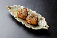 濃厚な蟹味噌を塗り、表面を香ばしく炙った、〆にぴったりの焼きおにぎりです。焦がした味噌の香ばしさと、中に混ぜ込まれた蟹のほぐし身の旨味が絶妙。