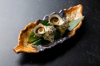 磯の香りを存分に楽しめる、新鮮なサザエのつぼ焼き。ぐつぐつと煮立つ醤油の香ばしい香りがたまりません。コリコリとした身の食感と、肝のほろ苦さがクセになる、通好みの味わいをご堪能ください。