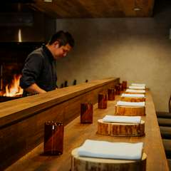 薪の炎と機敏なシェフたちの仕事を間近に感じるカウンター席