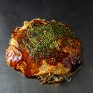 生地には庄原市・グリーンファームの卵を使い、焼き上がりに柔らかな食感をもたらした逸品。鉄板の温度管理や具材の重ね方にも工夫を施し、地元食材の特徴を丁寧に引き出しています。