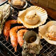 生食で楽しめる鮮度のたこぶつや、マグロの切り落としを卓上コンロで軽く焼き、香りと旨みを引き出した一品。さらに、季節ごとに選び抜いた魚介を盛り込み、貝類やエビなども一緒に盛り合わせています。