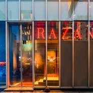 一部ガラス張りの外観から漏れる光が夜に映え、外からでも洗練された雰囲気が伝わります。店内はシックでモダンにデザインされ、とてもスタイリッシュです。計算されたテーブル席や照明の配置が、視覚的にも美しい。