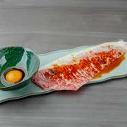 焼きは料理人に委ね、仕上げを自ら行う「ハーフアテンドスタイル」でいただく一皿。サッと炙った一枚肉を秘伝のたれと卵黄にくぐらせ、コクとまろやかさとの重なり合いを楽しめます。