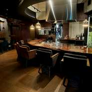 無垢材など木の風合いが美しい空間に、半円形のカウンター席・テーブル席・完全個室をゆったり配置。カウンターの一画に鉄板を設え、肉料理を焼き上げるライブ感を届けるなど、五感に響く演出も好評です。