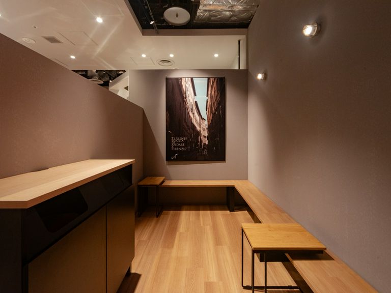 グレーの壁と木の温もりが調和する、イタリアンムードの店内