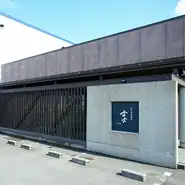 まつもと町屋駅から徒歩15分。高木中央1号公園前にあるのが【炭火焼肉割烹　士士】です。駐車場は9台分用意。都会の喧騒を離れ、非日常を体験できる隠れ家的な一軒です。
