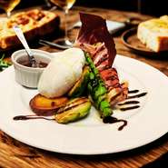 その日仕入れた季節の野菜を丁寧にグリル焼きし、ポーチドエッグと厳選生ハムを添えて。ソースはバルサミコとブルギニヨン