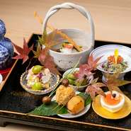 季節の野菜をたっぷり使ったおばんざい5～6種の八寸盛り。『翡翠銀杏と丸十とユリネの白和え』『大徳寺納豆とうるかを乗せた月見卵』など京都らしい品々が並びます。