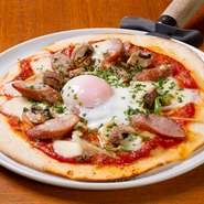 生地から店内で仕込むこだわりのピッツァは、限られた系列店でのみ味わうことができる隠れた人気メニュー。トマトソースの上に、ソーセージや刻み野菜、パルメザン＆モッツアレラチーズがたっぷりと乗っています。