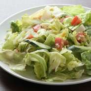 サラダは大、小、ミニからお好みでチョイス可能。レタス、胡瓜、トマト、ゆで玉子、ツナが入っていて、甘味と酸味のバランスが良いオリジナルドレッシングが味の決め手に。あらかじめ混ぜ合わせて提供されます。