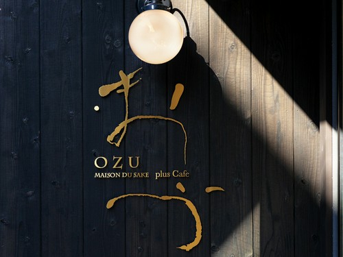 木の壁に金色で店名がかかれたオシャレな看板が目印