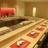 高級感ある上品な赤を差し色にコーディネイトされた店内は、ゆったりと座席を配置したゆとりあるつくり。世界が羨望する日本料理の技を目前に楽しめる、開放感あるオープンキッチンも魅力です。