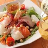 お造りでいただけるほど新鮮な海の幸をたっぷり乗せた贅沢なサラダ。自家製の和風ドレッシングで味わう一皿は、リーズナブルな価格も魅力。白ワインとあわせるのがオススメです。